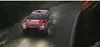 A red rally car driving on a wet road at night, with headlights on and spray coming from the wheels. Podgląd zdjęcia produktu