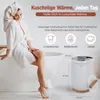 A woman in a bathrobe sits on the edge of a bathtub next to a towel warmer. Podgląd zdjęcia produktu
