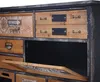 A close-up view of a vintage-style cabinet with multiple drawers and an open compartment. Podgląd zdjęcia produktu