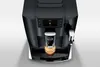 A top-down view of a black automatic coffee machine with a cup of coffee being dispensed. Podgląd zdjęcia produktu