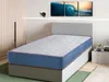 A mattress is displayed on a bed frame in a bedroom setting, with artwork on the wall and a closet in the background. Produktbild-Vorschau