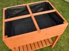 A wooden raised garden bed with a black liner, placed on grass. Voir les images du produit