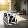 A dog is resting on a bed next to a dog crate in a modern room with a large window. Produktbild-Vorschau
