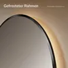 Close-up of a round mirror with integrated LED lighting, showing the frame and a portion of the reflective surface. Produktbild-Vorschau