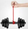 A hand holding a red cable that is wrapped around a dumbbell. Produktbild-Vorschau
