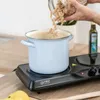 A person is pouring pasta into a pot on a portable electric stove. Náhľad obrázku produktu