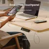 A person using a tablet and a laptop on a wooden desk, with a charging hub connected to both devices and a phone. Voir les images du produit