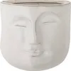 A white ceramic planter shaped like a face with closed eyes. Produktbild-Vorschau
