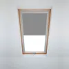 A skylight window with a grey roller blind partially lowered. Produktbild-Vorschau