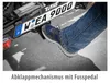 A person's foot is pressing a pedal on a bike rack attached to a vehicle. Produktbild-Vorschau