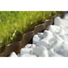 A close-up view of a garden border made of brown plastic, separating grass from white stones. Voir les images du produit