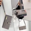 Collage of images showing a gray phone case with a wrist strap and a crossbody strap, featuring card slots and a zipper pocket. Produktbild-Vorschau