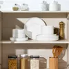 A well-organized kitchen cabinet with various dishes and food storage containers. Produktbild-Vorschau