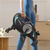 A person is holding a portable exercise bike in a room. Náhľad obrázku produktu