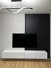 A modern living room setup featuring a wall-mounted TV and entertainment unit. Produktbild-Vorschau