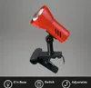 A red clip-on lamp with a black clip, shown against a plain gray background. Produktbild-Vorschau