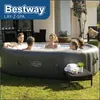 People enjoying a Bestway Lay-Z-Spa whirlpool in a backyard setting. Produktbild-Vorschau