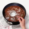 A hand is sifting powdered sugar onto a chocolate cake batter in a springform pan. Produktbild-Vorschau