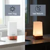 A split image showing a modern LED night light on a desk during the day and at night. Voir les images du produit