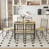 A dining set with a wooden table and four metal chairs is placed on a patterned rug in a kitchen or dining area. Náhled obrázku produktu