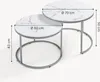Two nesting round coffee tables with marble-like tops and metal frames. Voir les images du produit
