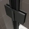 A close-up view of a black hinge on a shower door, set against a tiled wall and a white shower tray. Produktbild-Vorschau