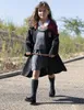 A young girl dressed as Hermione Granger walks outdoors, holding a wand. Produktbild-Vorschau