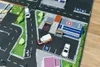 A toy play mat with miniature vehicles and buildings, including a hospital and ambulances. Produktbild-Vorschau