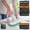 A person is using a white and gray handheld vacuum cleaner on a mattress. Produktbild-Vorschau