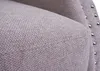 Close-up view of the textured fabric of a chair, showing decorative silver studs along the edge. Voir les images du produit