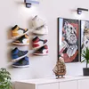 A wall display of sneaker shelves holding various pairs of sneakers. Produktbild-Vorschau