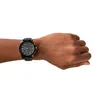A person's wrist wearing a black Armani Exchange watch. Podgląd zdjęcia produktu