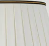 A close-up view of a pleated lampshade with a decorative trim. Podgląd zdjęcia produktu