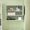 A white and green bathroom cabinet with its doors open, displaying various toiletries and bathroom supplies on its shelves. Náhled obrázku produktu