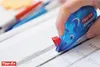 A hand is using a blue Tipp-Ex Pocket Mouse correction tape dispenser on a document with financial data. Anteprima dell’immagine prodotto