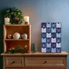 A Christmas-themed display on a wooden dresser, featuring an advent calendar, candles, and festive decorations. Náhľad obrázku produktu