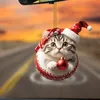A Christmas-themed cat ornament hanging in front of a blurred road and sunset. Produktbild-Vorschau