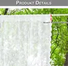 A white lace curtain hanging outdoors against a backdrop of green trees. Produktbild-Vorschau