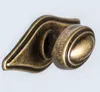 A close-up studio shot of a decorative metal hook with an antique bronze finish. Produktbild-Vorschau