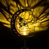 A solar garden light shaped like a crescent moon with a fairy and a glowing orb, casting a patterned shadow. Produktbild-Vorschau