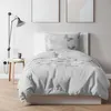 A bedroom scene with a bed, bedding, and a lamp. Produktbild-Vorschau