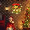 A young girl in a Santa hat sits on the floor surrounded by Christmas lights, with a decorated Christmas tree and wreath in the background. Produktbild-Vorschau