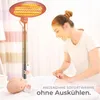 A woman is tending to a baby near a radiant heater. Produktbild-Vorschau