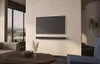 A modern living room with a TV and soundbar mounted on the wall. Produktbild-Vorschau