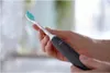 A person's hands holding an electric toothbrush. Anteprima dell’immagine prodotto