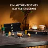 A still life arrangement of Nespresso coffee capsules, a coffee cup, a milk jug, and decorative elements. Produktbild-Vorschau