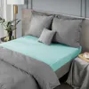 A bed with mint green fitted sheet and gray bedding. Náhľad obrázku produktu