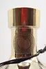 Close-up of the top of a gold-colored bottle with a circular emblem. Anteprima dell’immagine prodotto