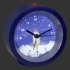 A close-up, slightly angled view of a blue alarm clock with a rocket ship design on its face. Podgląd zdjęcia produktu