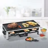 A raclette grill with food on it, set on a kitchen counter. Produktbild-Vorschau